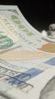 Kamera dolarların arasından beyaz toza kayıyor, ben de rulo halinde yüz dolarlık banknot, taklit ve uyuşturucu konseptiyle emiyorum. Dolly Slider aşırı yakın çekim. Dikey video.
