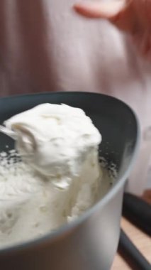 Kadın pasta için bir pasta torbasını kremayla dolduruyor. Dikey video.
