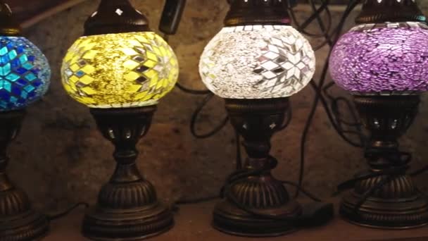 カラフルなガラス製のアンティークテーブルランプ 照明を販売する古いヴィンテージストア — ストック動画