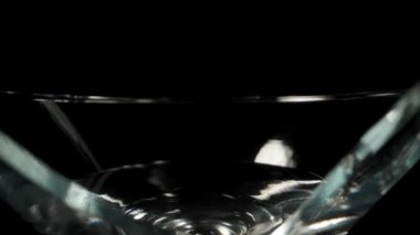 Kırık martini bardağında, bir zeytin düşüyor, ağır çekimde, dolly slider.