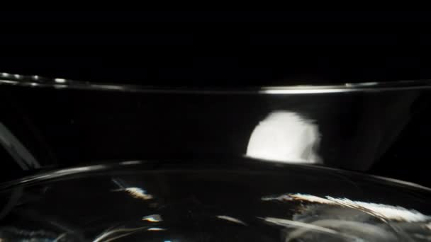 黒い背景に壊れたマティーニカクテルグラス 人形のスライダー極端なクローズアップ — ストック動画