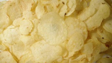 Düşme taklidi, konsept. Tek bir patates cipsi diğer çiplerin arka planına karşı tepeden tırnağa bir perspektiften döner..