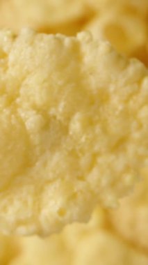 Düşme taklidi, konsept. Kahvaltıda mısır gevreği, tepeden tırnağa bir bakış açısıyla yakından çekilmiş, aşağı doğru düşmüş. Dikey video.