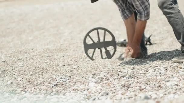 해변에 탐지기를 남자는 손으로 압도하고있다 뭔가를 발견했습니다 — 비디오