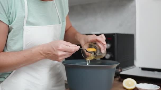 앞치마를 여자는 흰색을 노른자와 분리된 그릇에 넣습니다 장면은 슬로우 모션에서 — 비디오