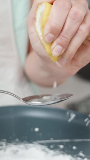 慢动作时 糕点厨师把半个柠檬挤进勺子里 然后把果汁倒入白色的蛋糕奶油中 垂直录像 — 图库视频影像