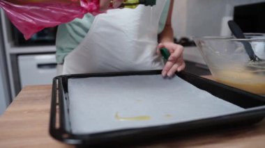 Pasta şefi bir şişeden yağını yavaş çekimde parşömen kağıdına döküyor..