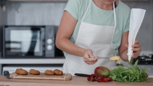 Młoda Kobieta Białym Fartuchu Kuchni Wypełnia Torbę Ciasta Kremem Ciasta — Wideo stockowe