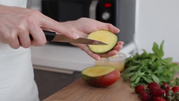 女性はマンゴーをキューブにカットし イチゴとミントを近くに置きます スローモーション — ストック動画