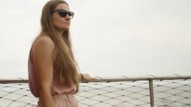 Pembeli genç bir kadın geminin korkuluklarına tutunuyor dalgalarla sallanıyor ve sonra geri dönüyor..