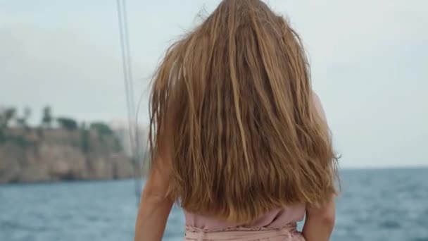 年轻女子的长发在风中飘扬 站在游轮的上层 凝视着遥远的城市 放大点 — 图库视频影像