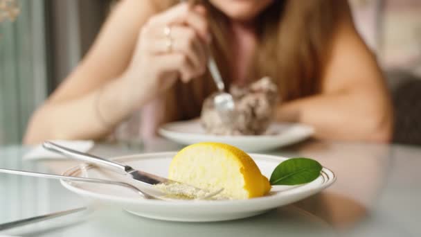 一对夫妇在咖啡馆里 我的柠檬慕斯在前景和一个年轻的女人吃她的蛋白糖卷为背景 — 图库视频影像