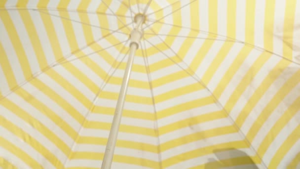 Plážový Deštník Bílými Žlutými Pruhy Poskytuje Stín Před Sluncem — Stock video