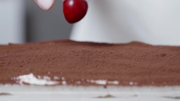 Bovenop Tiramisu Wordt Een Kers Geplaatst Met Cacaopoeder Close — Stockvideo