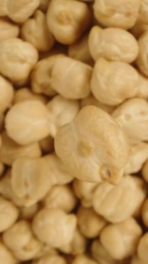 Nohut bir fındık kümesinin arka planında döner, tepeden aşağı bir perspektiften yakından bakıldığında görülür. Dikey video.