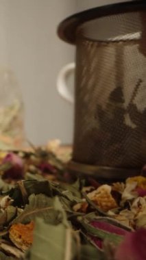 Çay yaprakları, dağınık çiçekler, çay seremonisi. Onlardan bir avuç dolusu mayalanmış eleğe koydum. Dikey video.