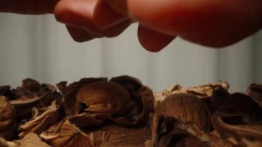 Masanın üzerinde, bir ceviz kalır, onu alıp ellerinizle kırarak açarsınız. Dolly kaydırıcı aşırı yakın çekim.