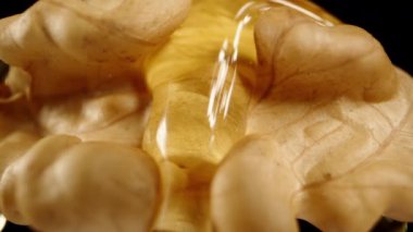 Kamera geriye doğru hareket ederken, üzerinde bal akan yarım bir ceviz. Makro Ayır.