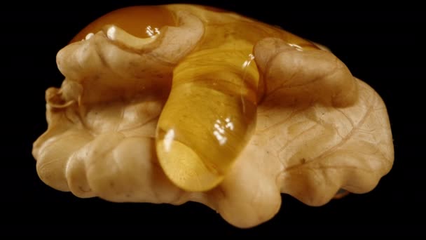 Ένα Ξεφλουδισμένο Καρύδι Μαύρο Φόντο Μέλι Στάζει Από Πάνω Μακρό — Αρχείο Βίντεο