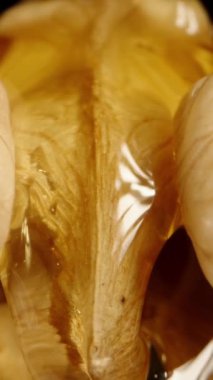 Üzerinde bal akan insan beynine benzeyen saflaştırılmış bir ceviz. Dolly Slider aşırı yakın çekim. Dikey video.