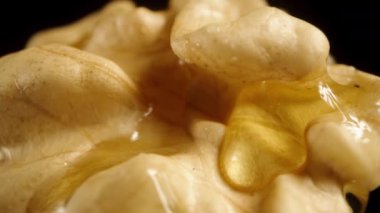 Kamera balla kaplı bir cevizin yarısından yavaşça uzaklaşır. Siyah arkaplanda makro çekim.