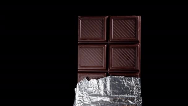 Uma Barra Chocolate Escuro Parcialmente Envolto Folha Brilhante Gira Fundo — Vídeo de Stock