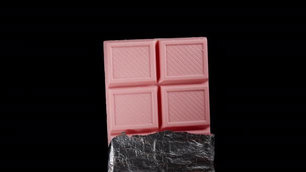 Een Half Omwikkelde Roze Chocoladereep Bedekt Met Glanzende Folie Draait — Stockvideo
