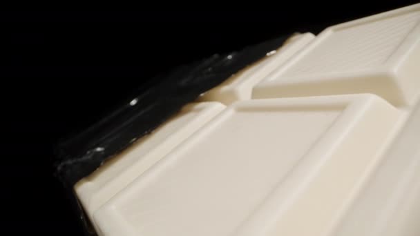 Большая Белая Шоколадка Частично Развернутая Фольги Кажется Погружается Темноту Макрозум — стоковое видео