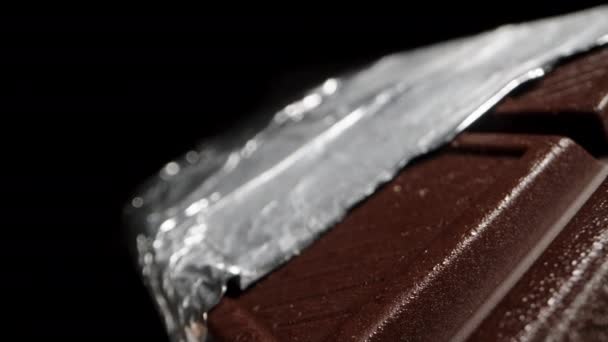 Uma Grande Barra Chocolate Preto Parcialmente Desembrulhado Partir Folha Isolado — Vídeo de Stock