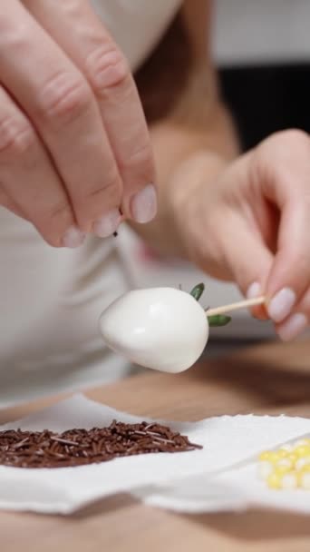 페이스트리 셰프가 초콜릿으로 딸기를 만들고 그녀는 초콜릿에 장식을 뿌립니다 비디오 — 비디오