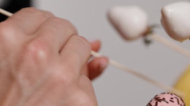 Bir kadın çikolata kaplı çilekleri diğerlerinin yanına özel bir standın içine yerleştiriyor..