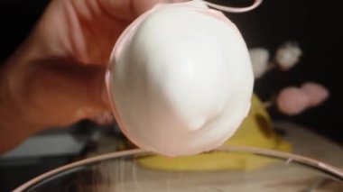 Beyaz çikolataya batırılmış ve pembe çikolatayla süslenmiş bir çilek resmi..