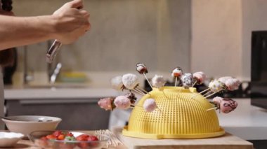 Kadın çikolataya batırılmış ve şeker parçacıklarıyla süslenmiş çilekler hazırladı. Şimdi de telefonuyla resimlerini çekiyor..