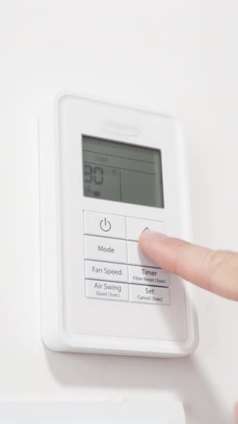 男性は 空調リモートコントロールで最も低い温度を設定します バーティカルビデオ — ストック動画