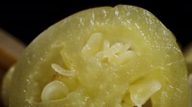 Kesilmiş yeşil Jalapeno biber dilimleri, siyah arka planda. Makro yakınlaştırma.