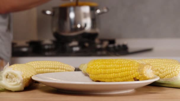 Silver Pot Background Woman Takes Out Hot Corn Cob Steam — Stock Video