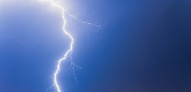 Siyah ve mavi gökyüzünden yıldırım. Fırtına bulutları.