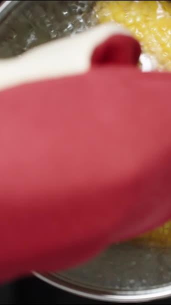 Вертикальное Видео Используя Красную Защитную Перчатку Поднимаю Горячую Крышку Кастрюли — стоковое видео