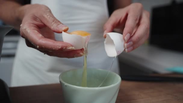앞치마를 여자는 껍질의 절반을 사용하여 노른자에서 흰색을 분리합니다 슬로우 — 비디오