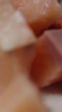 Dikey video. Küp şeklinde besleyici, kırmızı somon eti, yakın çekim görüntüsünde..