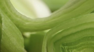 Siyah arka planda dilimlenmiş yeşil pırasa parçaları. Dolly kaydırıcı aşırı yakın çekim.