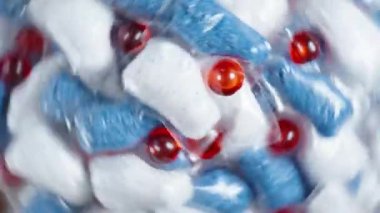 Bir bulaşık makinası için çoklu çözünebilir paketlerin arka planı, tepeden görüntülenir, döner.