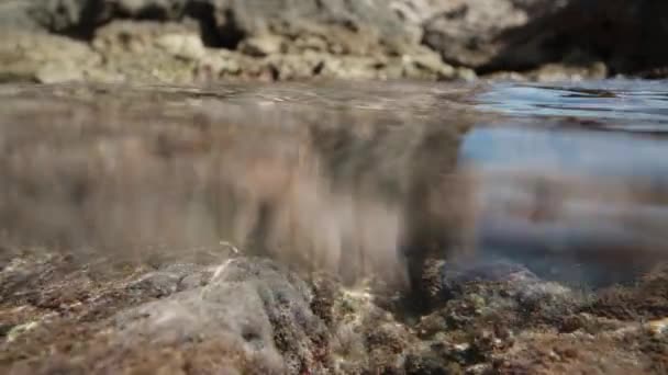 崖の岩の海岸 水の中のカメラは2つの世界 水と空の融合を捉えています — ストック動画
