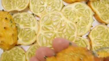 Kiwano 'nun dilimlenmiş salatalıkları tepeden görüldü ve elimde Kiwano' nun dikenli meyvelerinin yakın çekimi var..