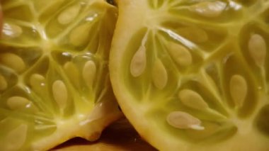 Kamera masadaki Kiwano 'nun yarımlarına yaklaşırken onları ellerimle ayırıyorum ve onların içinden geçiyor..