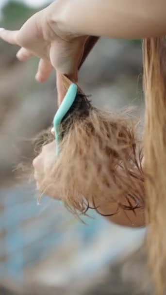 バーティカルビデオ 若い女性は 水の中に入った後 彼女の長く結びついた髪をかぶっています クローズアップショット スローモーション — ストック動画