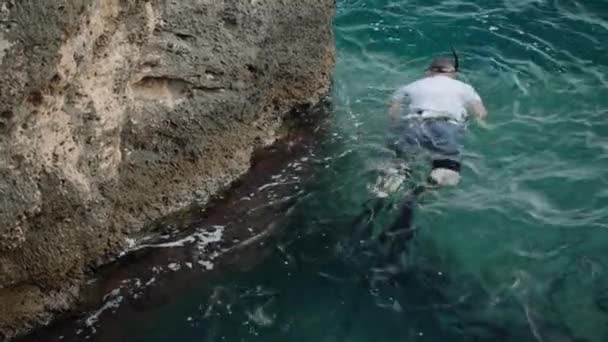 Yüzgeçli Maskeli Bir Adam Kayalıklarda Yüzer Balık Avlar Beline Bağlanmış — Stok video