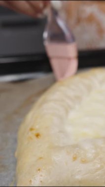 Dikey video. Bir kadın, Adjaran Khachapuri 'ye çırpılmış yumurta uygular. Yavaş çekim.