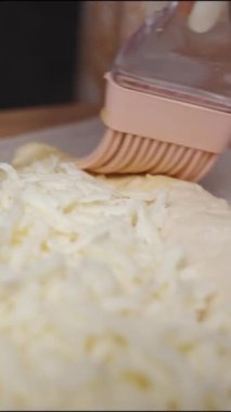 Dikey video. Hamuru çırpılmış yumurtayla fırçalarım Ajarian Khachapuri 'de altın bir kabuk oluşturmak için..