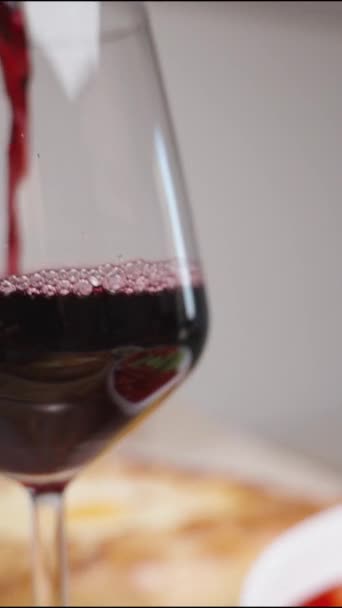 Κάθετο Βίντεο Κόκκινο Κρασί Χύνεται Ένα Ποτήρι Ενώ Στο Τραπέζι — Αρχείο Βίντεο